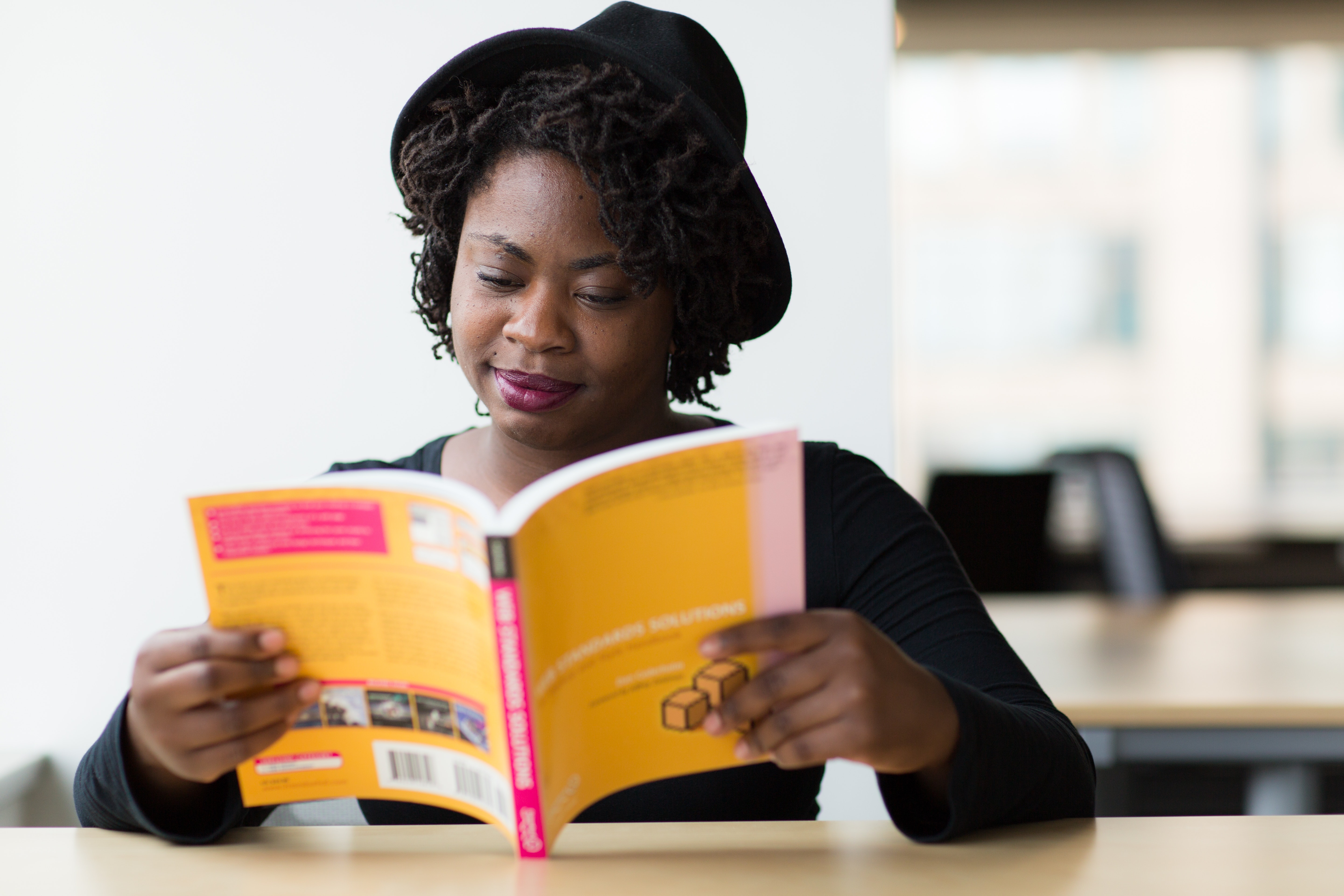 A Black woman reading a book.