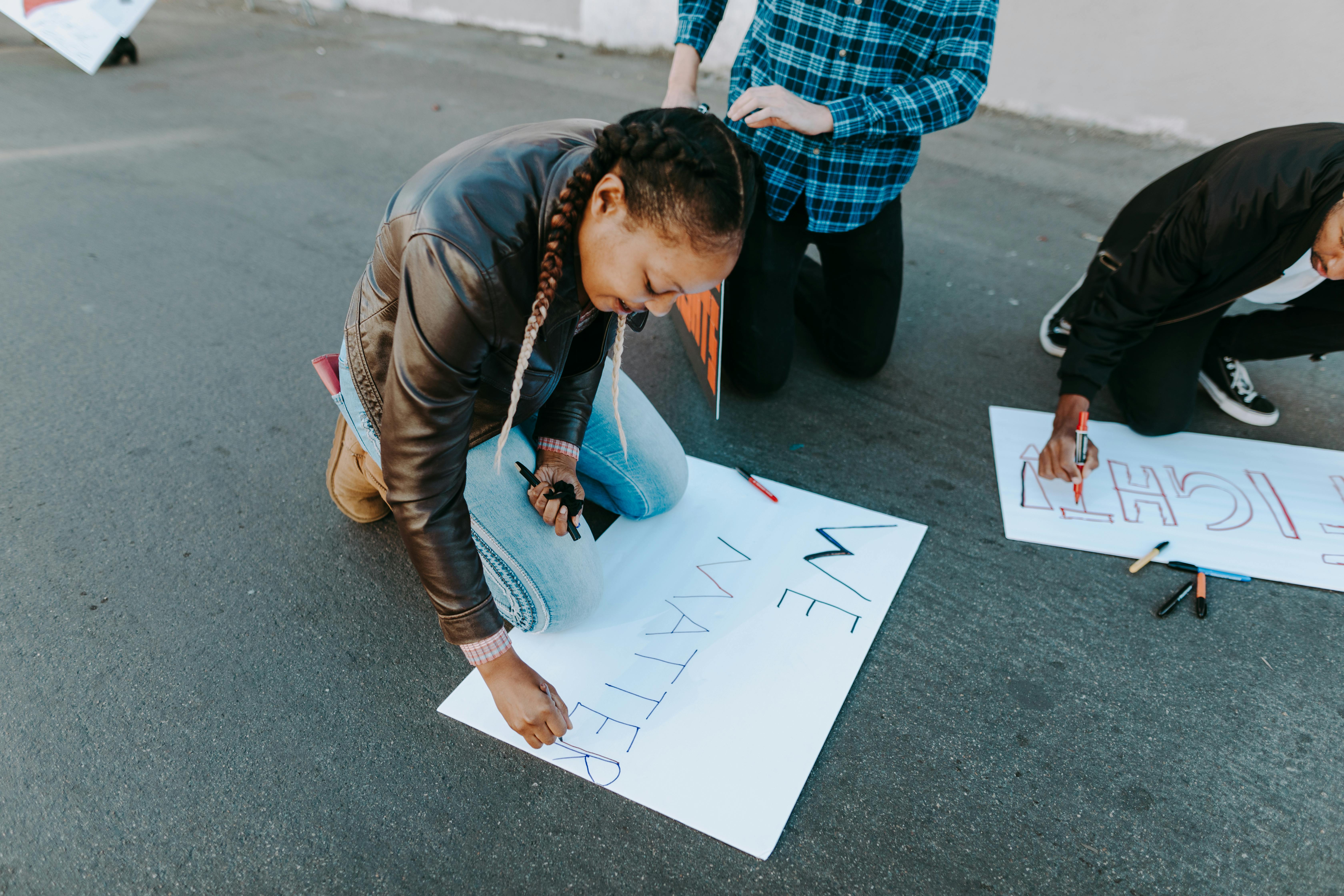 Girl creating a poster that reads "We Matter"